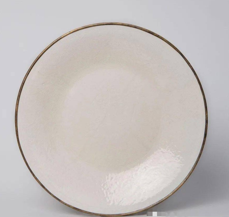 雍正時(shí)期仿定窯之作，與臺(tái)北故宮收藏的宋代定窯白釉雙魚(yú)盤(pán)十分相似